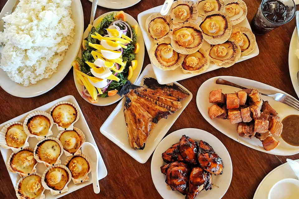 Seafood lunch spread in Roxas City, Capiz, with baked scallops, grilled fish belly, glazed grilled chicken, crispy pork, salad and rice